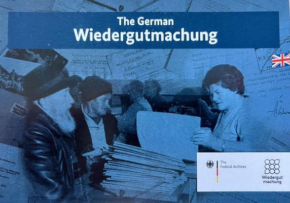 Promo postcard for the Wiedergutmachung project. Title: The German Wiedergutmachung. The theme depicted on the card is a blue tinted historical bw photo showing a woman (right) looking through files that are piled on a desk. Opposite there are two men sitting. One is wearing some traditional foreign hat. In the lower right corner, the logo of the German ministry of finances is depicted next to the Wiedergutmachung logo. There is also a small British flag (Union Jack) depicted on the right side,…