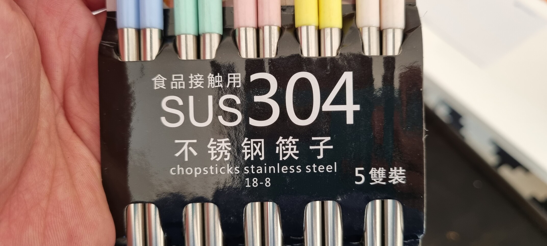 Close up of the packaging of chopsticks. There are some carachters I can't read but google translated them to things such as "nice lifestyle eating chopsticks".. The biggest text however is "SUS 304"