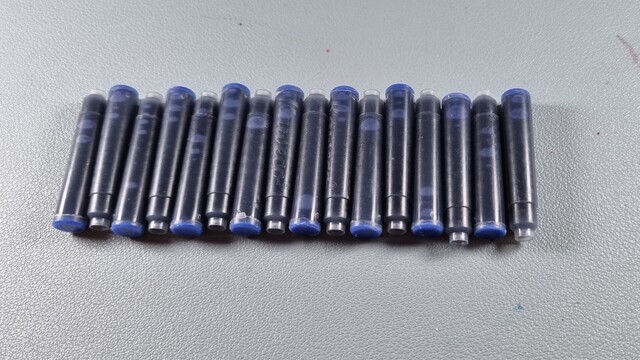 A bunch of short ink cartridges lined up. There are 16 of them and they're all filled with kaweco blue ink