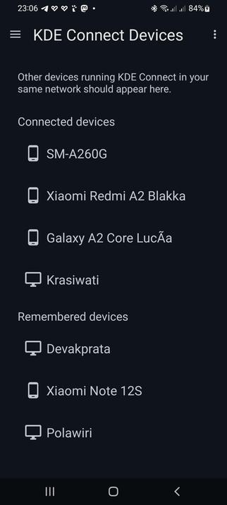 The image shows a mobile device screen displaying Konnect "KDE Connect Devices" interface. The background is dark, and the text is white, providing a clear contrast. At the top, the time is shown as 23:06, with various status icons indicating Bluetooth, Wi-Fi, and battery level at 84%. The main title "KDE Connect Devices" is prominently displayed, followed by a message stating that other devices running KDE Connect in the same network should appear here.

Below this, there is a section titled "Connected devices," listing four devices: "SM-A260G," "Xiaomi Redmi A2 Blakka," "Galaxy A2 Core Lucã," and "Krasiwati," each accompanied by a device icon. The "Remembered devices" section follows, listing three devices: "Devakprata," "Xiaomi Note 12S," and "Polawiri," each with a corresponding icon. The interface is designed for easy navigation, with a menu icon on the left and a back arrow on the right, indicating the ability to return to the previous screen.

 Ovis2-8B

🌱 Energy used: 0.264 Wh