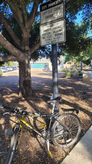 Mountain bike in front of "no bicycling" sign at the park at City Hall