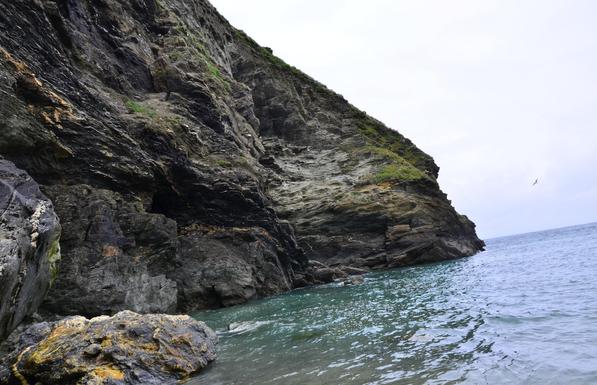 Placid sea and cliff.