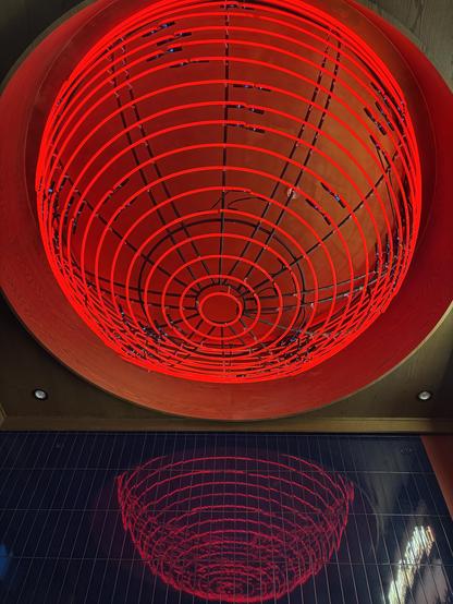 Large glowing ceiling light installation which resembles a cherry.