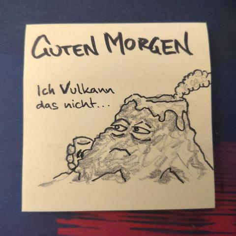 Auf einer gelben Haftnotiz steht "guten morgen" darunter ist ein leicht rauchender, müder Berg mit Kaffeetasse zu sehen.
Er sagt "ich Vulkann das nicht..."
