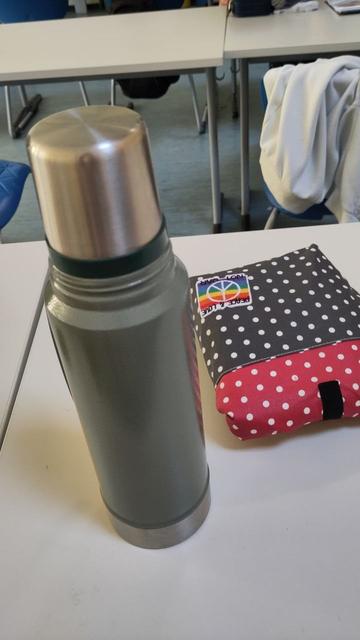 Grüne Thermosflasche und rotgrüne kleine Kühltasche