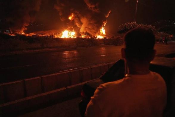 A man looks at flames rising from an oil storage facility after it appeared to have been struck by an Israeli strike in Tehran, Iran, early Sunday June 17, 2025 (Vahid Salemi/AP) A man looks at flames rising from an oil storage facility after it appeared to have been struck by an Israeli strike in Tehran, Iran, early Sunday June 17, 2025 (Vahid Salemi/AP)