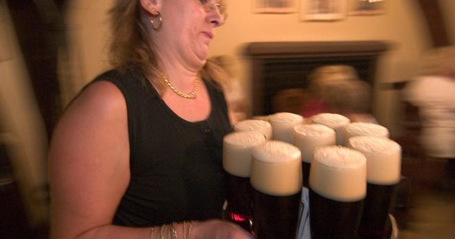 Eine Kellnerin bringt ein Tablett mit Bamberger Rauchbier an einen Tisch im Schlenkerla, einer alten Braustube in Bamberg.