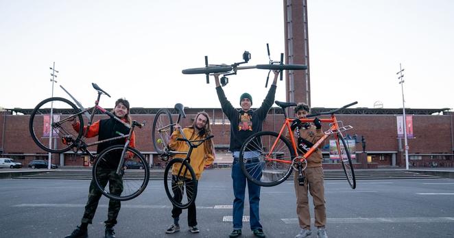 Four cast members hold up their bicycles for a photo during filming for The Engine Inside