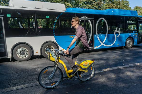 Ein Fahrradfahrer fährt an einem Bus vorbei