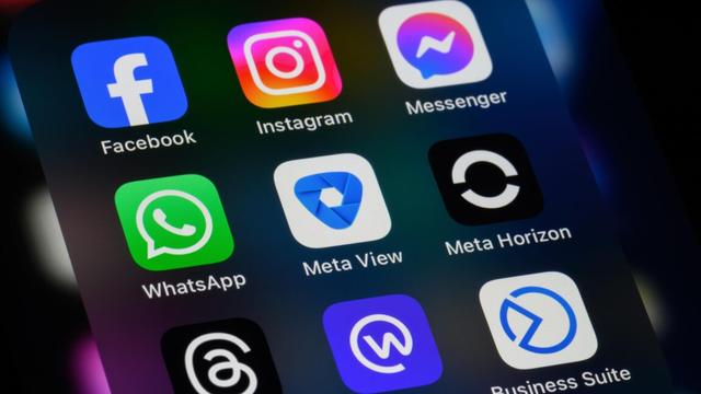 A phone screen displays app icons for Meta apps Facebook, Instagram, Messenger, WhatsApp, Meta View, Meta Horizon, Threads, Workplace, and Business Suite.
