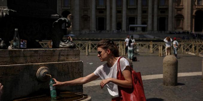 A visitor fills her bottle with water from a fountain on St. Peter’s Square, during a heatwave, at the Vatican, 23 July 2025. | ALKIS KONSTANTINIDIS / REUTERS