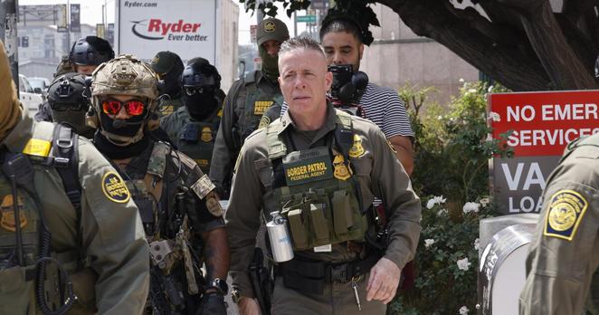 Los Angeles, CA - August 14: Gregory Bovino, Chief Patrol Agent of the El Centro Sector and Commander-Operation At Large CA (center), marches with federal agents to the Edward R. Roybal Federal Building after US Border Patrol agents produced a show of force outside the Japanese American National Museum where Gov. Newsom was holding a redistricting press conference on Thursday, Aug. 14, 2025 in Los Angeles, CA. (Carlin Stiehl / Los Angeles Times)