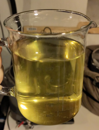 Halvliters målebeger i glass, fylt med gyllen einelåg etter en times trekking.