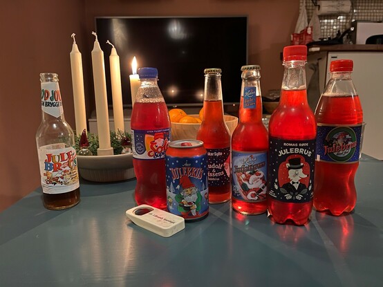 Tent adventstake. En åpen Hamar-julebrus står ved siden, og det er seks varianter av rød julebrus i midten.