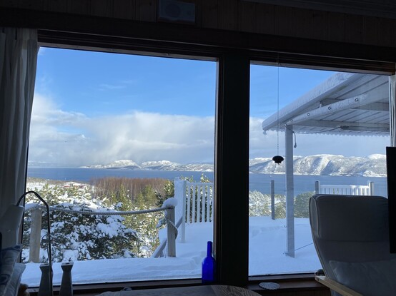 Utsikt fra hyttevinduet. Trondheimsfjorden og snødekte fjell på Fosen på andre sida. Sol! 