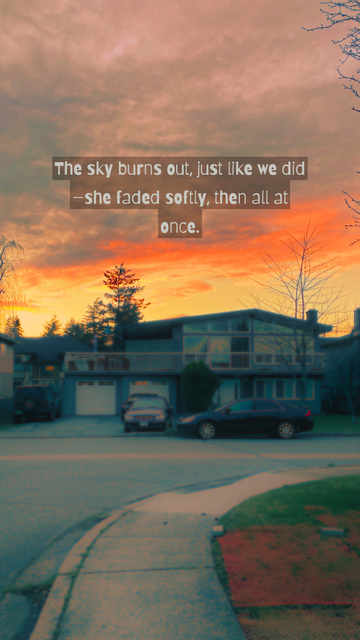 A stunning sunset with orange and pink hues fading over a quiet suburban neighborhood. Overlaid text reads, "The sky burns out, just like we did—she faded softly, then all at once."