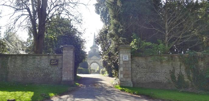 A gateway to 'Over Court', with an arch/clock tower beyond.