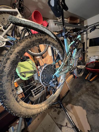 Photo of dirty Mountain Bike on work stand with freshly cleaned drive train.