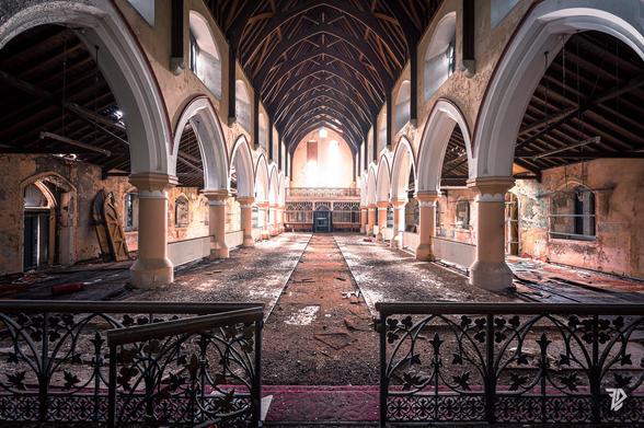 an abandoned church, light coming by broken stained glass