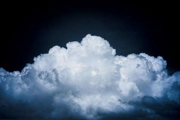 Photo of a large cloud with a darkened sky making it look like a puff of smoke or fuzz