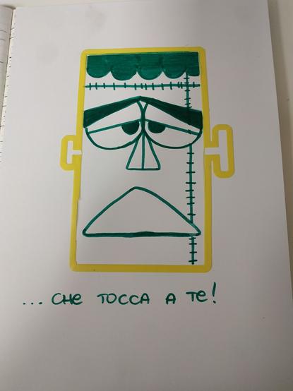 un foglio bianco con un profilo di plastica giallo (lo scarto di una stampa 3d) al cui interno è stata disegnata in verde la faccia di Frankenstein in versione Carletto il principe dei mostri.
sotto la frase finale della vecchia sigla "... che tocca a te!"