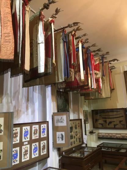 various Polish regimental and other military flags hang from horizontal rods with eagle finials just beneath the ceiling in one of the museum's small exhibit rooms

more here: 
https://pism.org.uk/sikorski-museum/