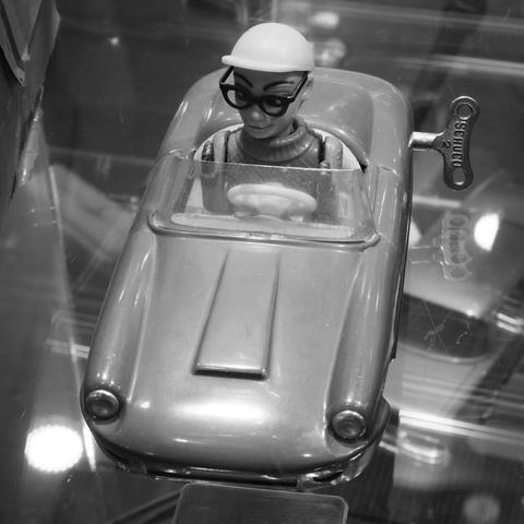 Ein kleiner Rennwagen aus Blech mit einem Fahrer von der Firma Schuco. Hinten sieht man den Schlüssel mit der man das Auto aufziehen kann.