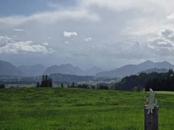 Wiesen, Hügel, Berge, Regenwolken.