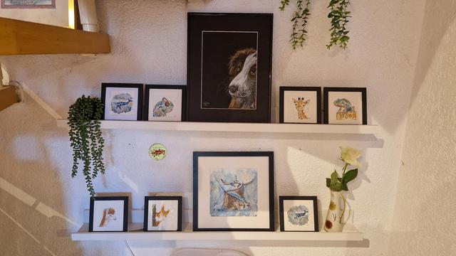 Auf zwei Borden aufgereiht sind 8 handgemalte Bilder, eins davon ein unverkäufliches Portrait meiner Hundedame auf den anderen zweimal Chamäleon einmal Alpaka zweimal Wal und einmal Giraffe, einmal Eichhörnchen und ein größeres Bild mit Rochen