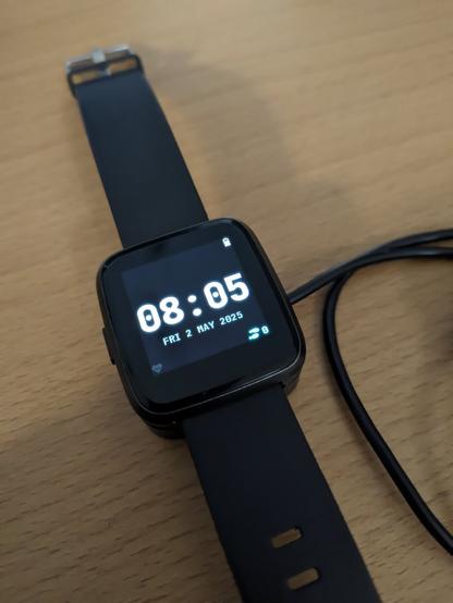 Eine PineTime Uhr mit aktivem Display, das die Uhrzeit 8:05 Uhr anzeigt.