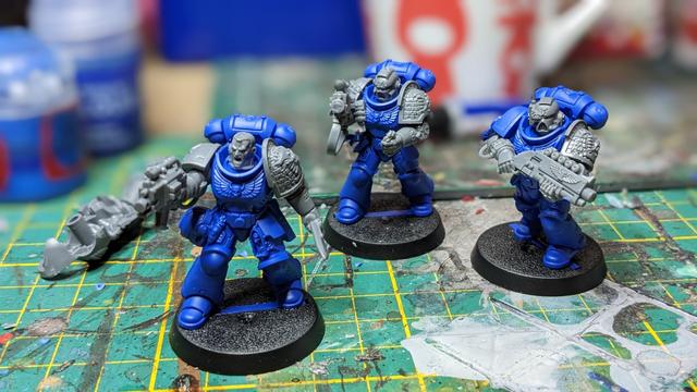 Three unpainted Space Marines with blue bodies.