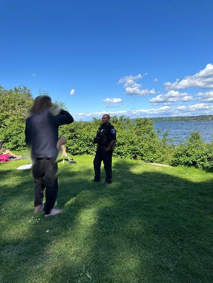A cop mills around the park, inspecing beach goear's attire
