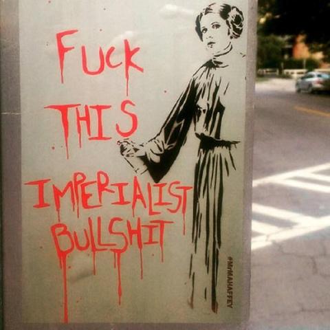 Stencil graffiti of Princess Leia standing, while holding a can of spray paint, next to written graffiti that says, "Fuck this Imperialist Bullshit".