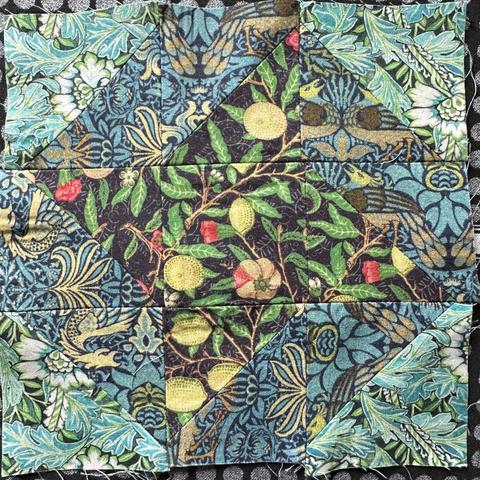 A 9 section block for quilting. It’s made up of half square triangles and there main motif is a friendship star. The fabrics used have a lot of patterns going on. William Morris inspired patterns. There’s flowers and birds and lemons.