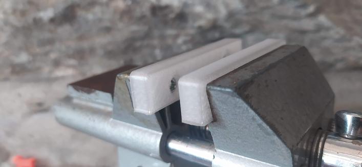 A small bench mount vice with a close up on the jaws. The small rectangular jaws are 3d printed in PET filament salvaged from a pop/soda bottle via my pullstruder.