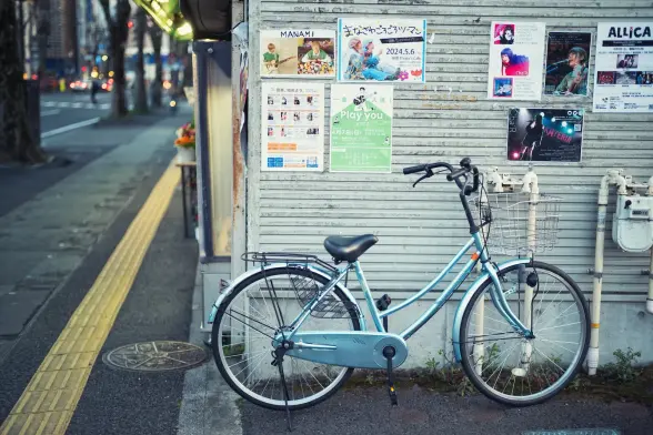 Bicycle next to a wall with posters on the street