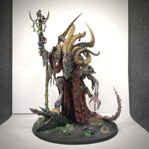 Huge, multi-horned rat demon walking upright over green-glowing ruins surrounded by skittering rats. He carries a staff, has a sword at his hip, and wears red robes and a sash. All are glowing with green runes, including Vizzik’s back.