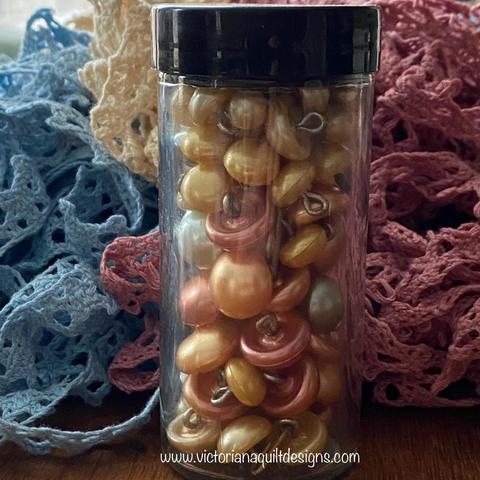 Small jar of shiny shank buttons.