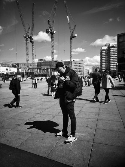 Man watching him phone in Alexanderplatz, Berlin