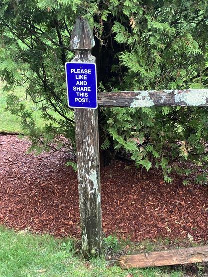 Post of a fence with a sign that reads "Please like and share this post"
