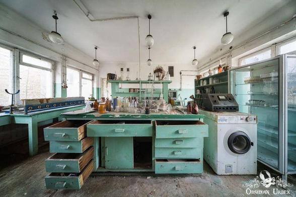 abandoned laboratory, lad equipment and bottles on a green desk. dead plants