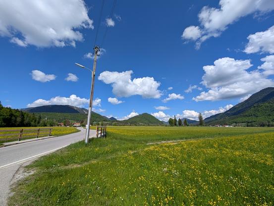 Blühende Jachenau unter weiß-blauem Himmel.