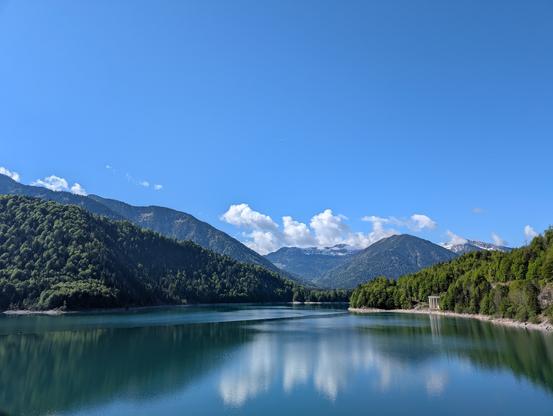 Sylvensteinspeicher. Im Hintergrund strahlend blauer Himmel und Berge.