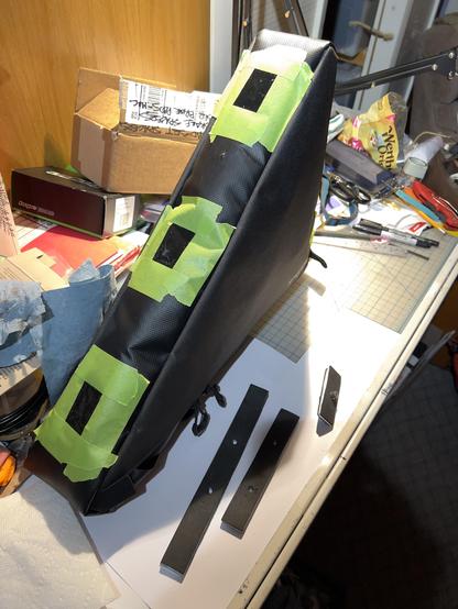 Photo shows Sealing up of stitching holes from removed Velcro straps with clear silicone adhesive sealant for Salsa Triangle frame pack customization on my Marin Pine Mountain eTrail bike project build.
