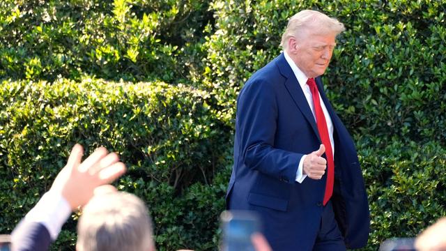 Präsident Donald Trump verlässt eine Pressekonferenz und geht am Publikum mit der Geste des erhobenen Daumens vorbei.