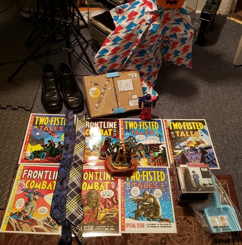 A haul of thrifted items, including 9 prints from EC war comics (8 by Harvey Kurtzmann & 1 by Jack Davis), 2 neckties, 2 CDs (another 1 was discarded upon learning the sleeve was empty), 4 VHS tapes, a pair of Beatles boots, a cardboard SLR camera kit, a short-sleeved buttondown David Bowie shirt featuring the "Aladdin Sane" lightning bolt motif, 2 Egyptian fantasy figurines, an ornament of The Nostromo from 20,000 LEAGUES BENEATH THE SEA, a handpainted glazed robot figurine, and a cat litter box poop scoop.