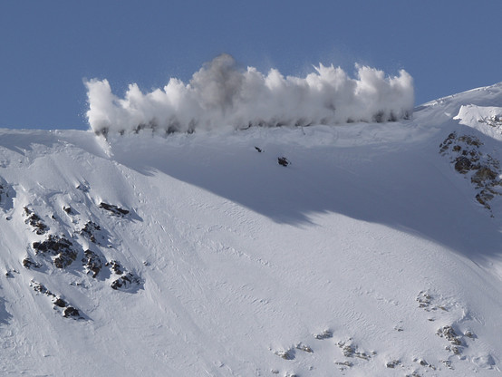 Cornice Blast

This is an image of a controlled explosion on a mountain ridge at Snowbird Ski Resort. The ski patrol had been out working all night knocking down avalanches with their howitzers and other means.
On the first run of the day people were being held up at the top of the chair so the ski patrol could eliminate the avalanche risk.
At the top of the ridge line the ski patrol had set up what looks to be roughly 30 or so charges across the cornice and then fired them all off at once. I captured the charges just as they went off and the snow is just starting to break loose from the mountain.