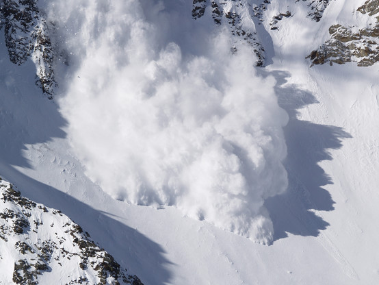 Avalanche III

This is the third image in a series of an avalanche I was able to capture form the top of a ski lift at Snowbird resort in Utah.
In this image the main chute of the avalanche has landed in a natural bowl and is starting to spread out as it continues down the mountain. 
It appears that the avalanche is occurring under the surface layer of snow and is pushing the snow upwards and outwards. 