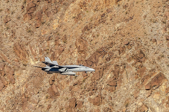 F18 Level Flight In Star Wars Canyon 

This is an image of an F18 flying through Star Wars Canyon in Death Valley National Park. 
I captured this image just east of the Father Crowley's overlook for the official name of this area, Rainbow Canyon.
Here the jet is near level with the south wall of the canyon banking slightly left before the pilot dropped further into the canyon. 
The background is the north wall of the canyon. The wall is barren and rocky and certainly poses a hazard to the jets flying through here.
