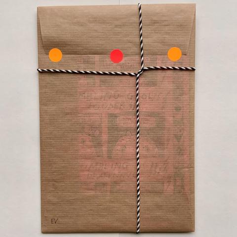 This is the back of the envelope, with the black and white string, and three orange/red stickers that seal the envelope flap. 